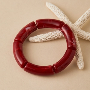 Donkerrode acryl armband met gebogen buizen en marmeren textuur in retro vintage stijl