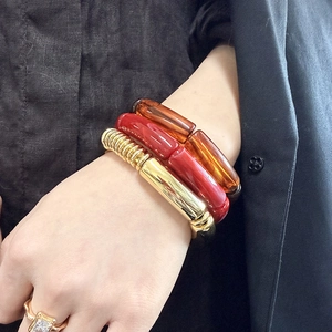 Stacked acrylic leopard print bangles and golden metal bracelets for a trendy layered look