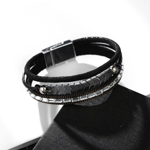 Nahaufnahme eines Bohème-Armbands mit schwarzen Schnüren, Strass und silbernem Magnetverschluss