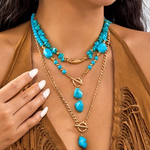 Bohemian layered gold chain necklace with turquoise stones and toggle clasp detail