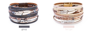 Détail de bracelets bohèmes en cuir gris et beige avec un charme de plume en métal