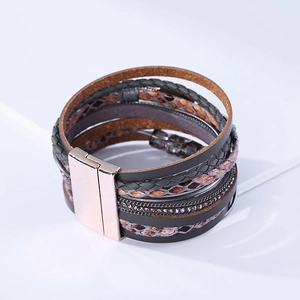 Détail d'un bracelet multicouche en cuir bohème avec motif serpent et fermoir magnétique