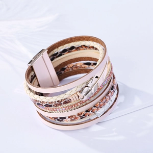 Détail du bracelet bohème multicouche en cuir avec cristaux roses et pendentif plume