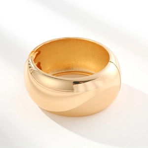 Polished gold-plated chunky mirror finish spring open cuff bangle in minimalist style