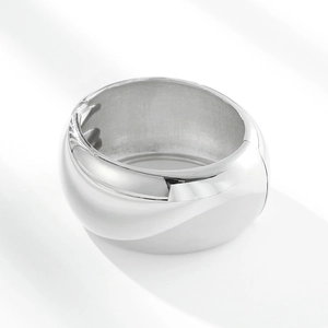 Macro view of wide polished silver alloy bangle with functional hinge mechanism