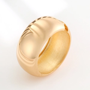 Polished gold wide metal bangle with smooth mirror finish and internal brushed texture