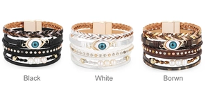 Detalle de pulseras multicapa de cuero con amuleto ojo turco, perlas y tachuelas
