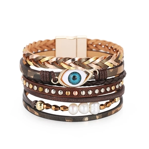Detalle de pulsera de cuero multicapa con amuleto de ojo, perlas y cierre magnético