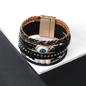 Detalle de pulsera de cuero bohemia con amuleto ojo turco, perlas y cierre magnético oro