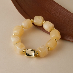 Detailed shot of irregular acrylic bead bracelet with golden metallic marble texture accents
