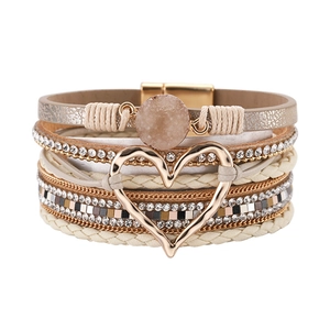 Detail van een gelaagde bohemian armband met hartvormige hanger en magneetsluiting