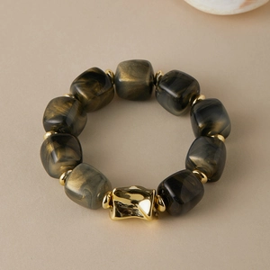Detail of acrylic bracelet featuring black marble texture resin beads and gold accents
