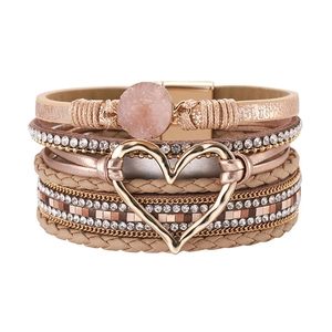 Detail van meerlaagse boho-armband met hartbedeltje en sprankelende strass-bandjes
