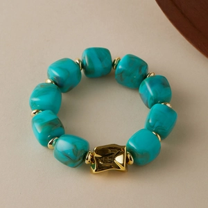 Detail of turquoise marble beads and textured gold irregular metal element on the bracelet
