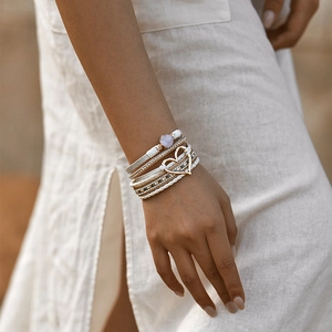 Detail van de bohemien meerlaagse armband met gouden hartvormige bedel en kristallen