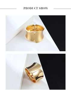 Détails d'un large bracelet doré avec finitions mates brossées et polies miroir