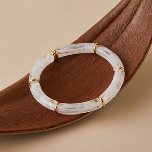 Detail of bohemian tube stretch bracelet with white marble resin and gold metal spacers