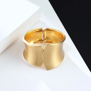 Bracelet jonc large doré minimaliste avec finition en métal brossé et charnière à ressort