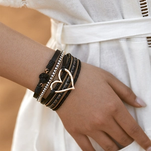 Detail van bohemien meerlaagse armband met gouden hartbedel en fonkelende strasband