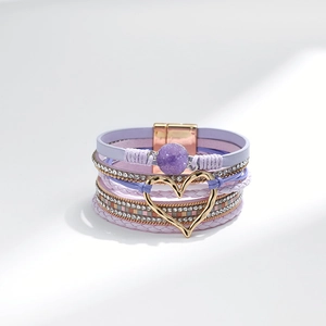 Detail eines mehrlagigen Boho-Armbands mit lila Leder, Herzanhänger und Magnetverschluss