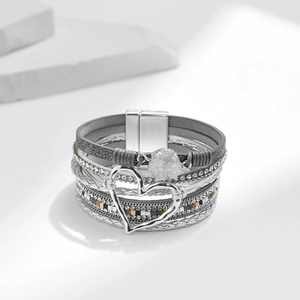 Details des mehrlagigen Boho-Armbands mit Herzanhänger und Magnetverschluss auf Steinen