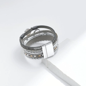 Detailansicht eines mehrlagigen Boho-Armbands mit grauem Leder, Strass und Magnetverschluss