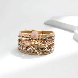 Details des mehrlagigen Lederarmbands mit goldenem Herzanhänger und rosa Stein