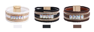 Dettaglio di bracciali bohémien multistrato in pelle con cristalli e chiusura magnetica