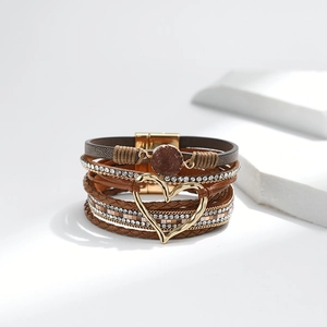 Detail eines Boho-Armbands mit Herzanhänger, Strasssteinen und goldenem Magnetverschluss