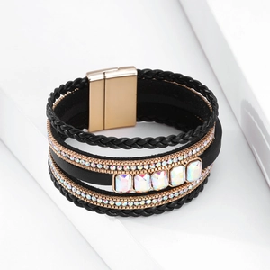 Dettaglio di bracciale bohémien multistrato in pelle con cristalli e chiusura magnetica