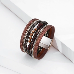 Dettaglio di bracciale multistrato boho con strass, perline e chiusura magnetica dorata