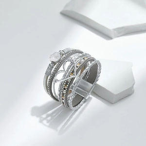 Detail eines Boho-Mehrschicht-Armbands mit Herzanhänger und Magnetverschluss auf Stein