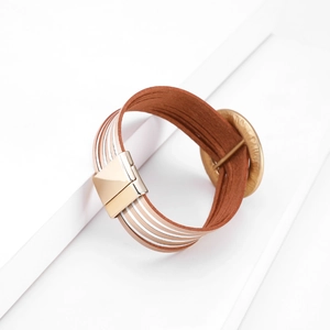 Dettaglio di bracciale multistrato in pelle boho con chiusura magnetica in oro rosa