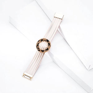 Dettaglio del bracciale multistrato in pelle bianca con anello leopardato e chiusura