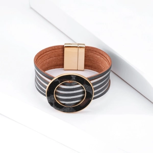 Dettaglio di un bracciale multistrato in pelle con trama in crine e chiusura magnetica