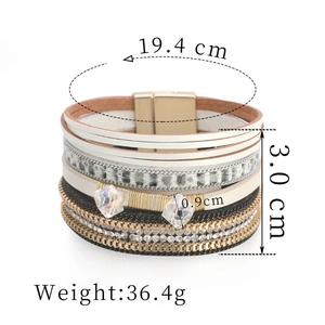 Detailweergave van de meerlaagse lederen armband met maten en luipaardprint textuur