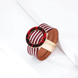 Dettaglio del bracciale multistrato in pelle bordeaux con fibbia tonda leopardata