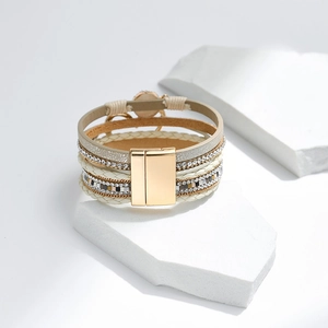 Detail eines mehrlagigen Boho-Armbands mit Strasssteinen und Magnetverschluss in Gold