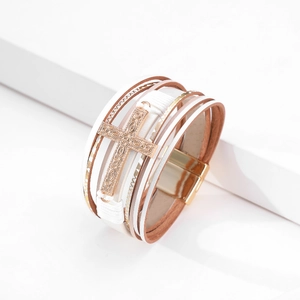 Detail of multilayer leather bracelet with rose gold cross and magnetic clasp