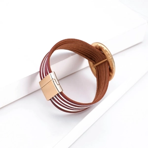 Dettaglio del bracciale in pelle bordeaux multistrato con chiusura magnetica oro e disco