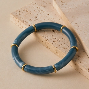 Detail of bohemian tube beads bracelet with dark gray marble texture and gold accents