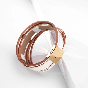 Close-up of multilayer leather bracelet with embossed patterns and gold magnetic clasp