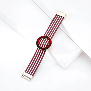 Dettaglio bracciale in pelle rossa a righe con ciondolo leopardato e chiusura magnetica d'oro