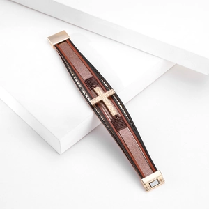 Detail of multi-layer leather bracelet with engraved cross and golden magnetic clasp