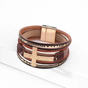 Detail of multi-layer leather bracelet with cross embossment and gold magnetic clasp