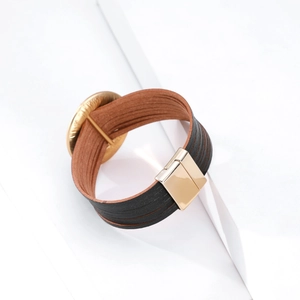 Dettaglio del bracciale multistrato in pelle boho con chiusura magnetica e anello d'oro