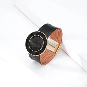 Dettaglio del bracciale multistrato in pelle nera con chiusura magnetica dorata e inserto in pelo