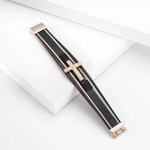 Detailed macro of multilayer leather bracelet featuring a rose gold engraved cross and magnetic clasp
