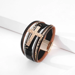 Detailed close-up of multi-layer leather bracelet with cross emblem and magnetic clasp