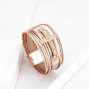 Detail of bohemian multilayer leather bracelet with embossed patterns and cross charm